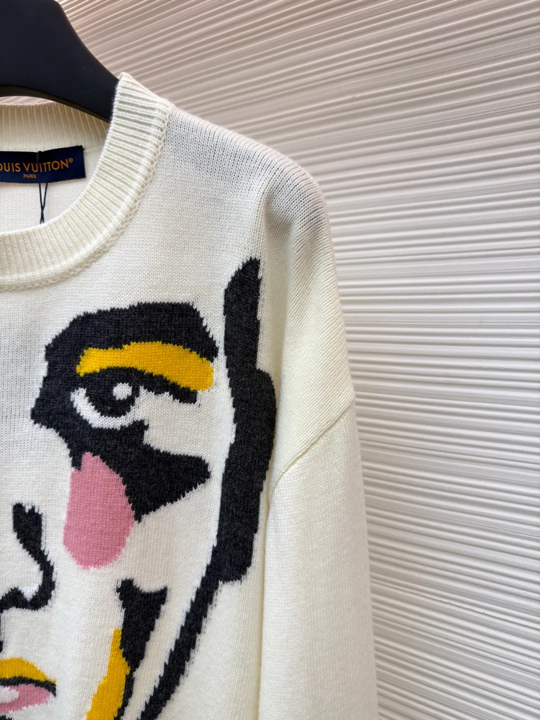 LOUIS VUITTON Portrait Grimace Jacquard Sweater ●Original version: 13100 purchase and development ●Item number: 1681807-B50 ●Fabric: wool blended fabric ●Technology: jacquard knitting ●Color: off-white ●Version: fitted version ●Weight: about 470 grams ●Size: XS-S-M-L ●Description: This human face jacquard sweater is made of 12-needle high-density worsted wool blend yarn, with a soft and crisp texture. The main face pattern uses intarsia jacquard technology, and is precisely interwoven with multi-color yarns such as black, blue, and green. There are no floating lines on the edges of the pattern, and the color levels are clear and not easy to fall off. The collar, cuffs and hem are all made of ribbed edge technology, which has excellent elasticity and will not deform after long-term wear. The seams on the body are double-needle seamed, and the details are reinforced and durable; the shoulders are made of seamless weaving technology, so there are no indentations and a better fit when worn. The overall shape is adapted to various body shapes through three-dimensional tailoring, and the manual measurement error is controlled within ±3cm, taking into account both design and practical wearability. The overall wiring is straight and delicate, the fabric is comfortable and soft, and the color is consistent without color difference. It can be matched with the same style to create a fashionable look and control various occasions. Customized accessories, complete with three standards, same style for men and women!